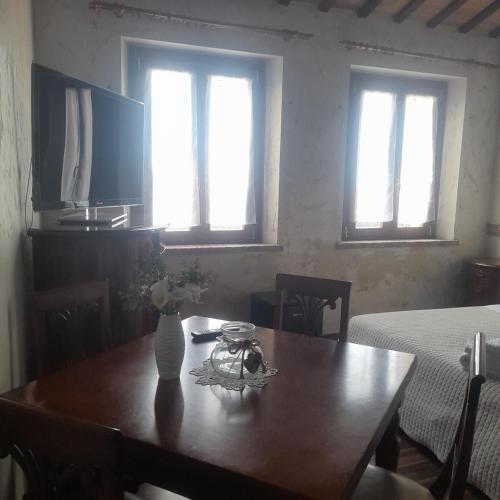a dining room table with a vase of flowers on it at Casale della rosa in Loreto