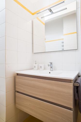 a bathroom with a sink and a mirror at Viverenumana appartamenti la tua casa in centro a pochi passi dal mare in Numana