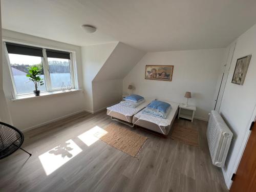 sypialnia z 2 łóżkami i oknem w obiekcie Hyggelig lejlighed w mieście Bindslev