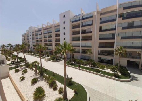 un grande edificio con palme di fronte di MAR y SAL a Roquetas de Mar