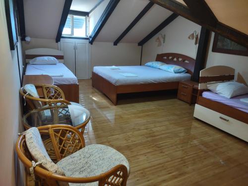Habitación con 2 camas y sillas en un ático en Captain's House in Dobrota, en Kotor