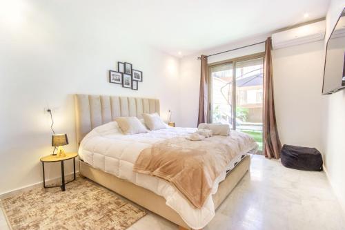 a bedroom with a large bed and a large window at NEW!, Jardin privé, transats, barbecue in Marrakech