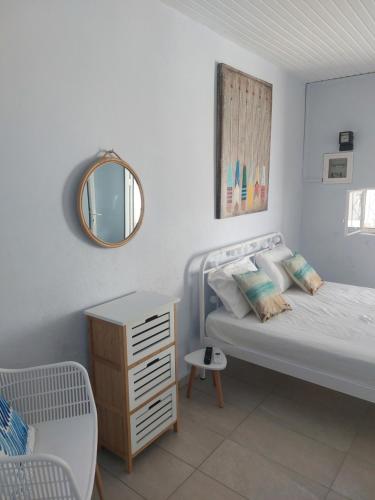 a white bedroom with a bed and a mirror at Vitamin Sea house in Panayía