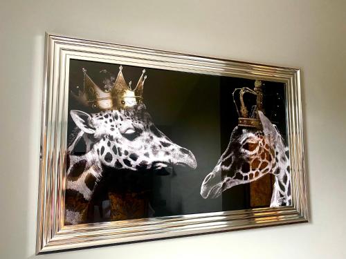 a picture of a giraffe with a crown on its head at 3 West End Boutique Apartment in Bowness-on-Windermere