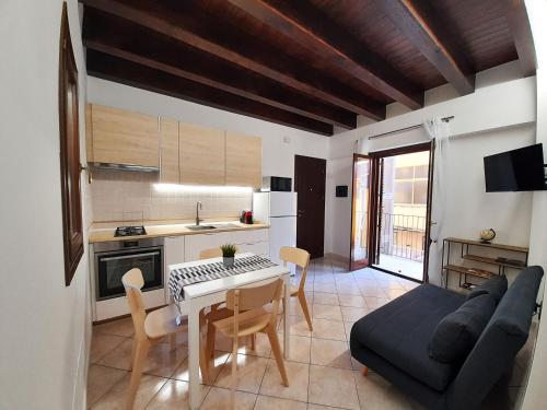 eine Küche und ein Wohnzimmer mit einem Tisch und einem Sofa in der Unterkunft I Vicini del Re Holiday Home in Palermo