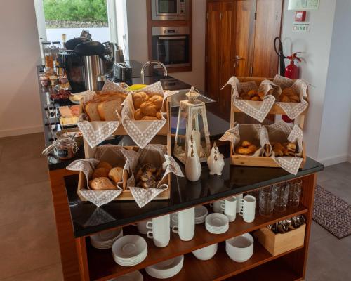 une vitrine avec différents types de pain dans l'établissement Casa dos Romeiros, à Santa Bárbara