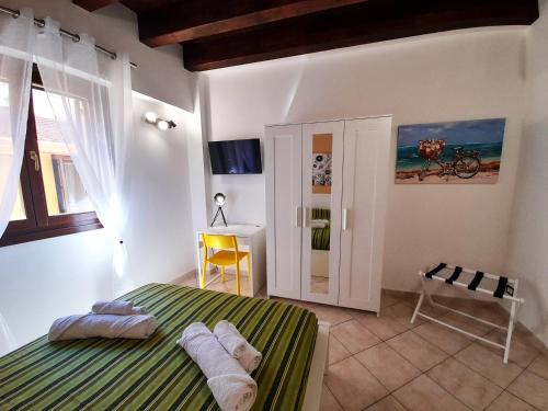 Schlafzimmer mit einem grünen und weißen Bett und einem Schreibtisch in der Unterkunft I Vicini del Re Holiday Home in Palermo