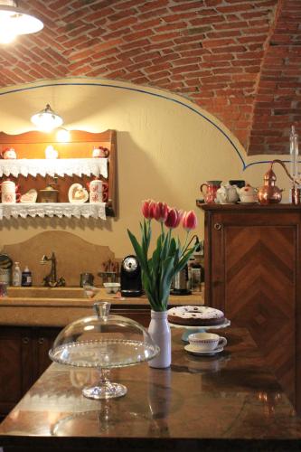 eine Küche mit einer Theke mit einer Vase aus Tulpen in der Unterkunft B&B Chez Annie in Donnaz