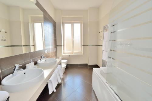 Baño blanco con 2 lavabos y bañera en Eden Penthouse Apartments, en Zadar