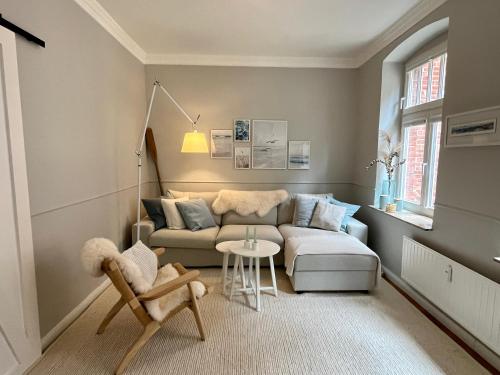 a living room with a couch and a table at 3 Zimmer Ferienwohnung Burghof mit Balkon im Herzen Flensburgs in Flensburg