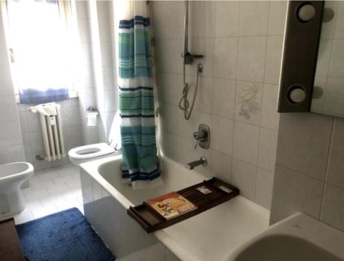 y baño con lavabo, aseo y toalla. en camera in via Tolstoi, en Milán
