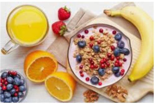 a plate of cereal and fruit and a glass of orange juice at ViNALUX in Vinaròs