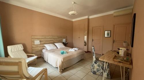 um quarto com uma cama, uma secretária e uma cadeira em Château La Sabine em Saint-Laurent-de-la-Cabrerisse