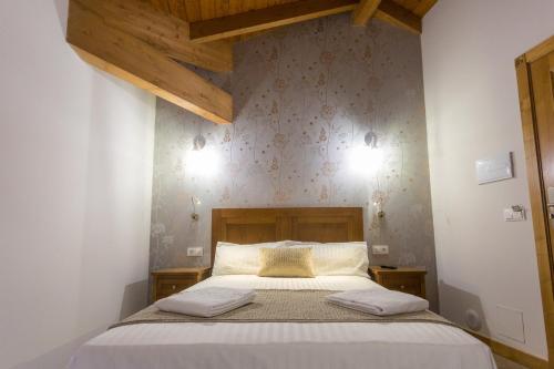 ein Schlafzimmer mit einem Bett mit zwei Kissen darauf in der Unterkunft Casa da Ponte de Penas in Melide