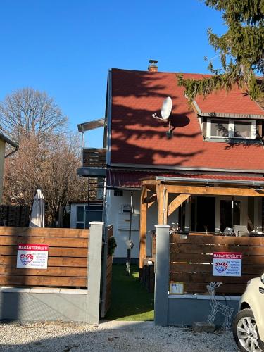 a house with a wooden fence in front of it at Balcsitthon Apartmanok in Siófok