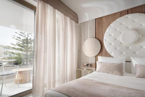 a bedroom with a large bed and a large window at Nautilux Rethymno by Mage Hotels in Rethymno Town
