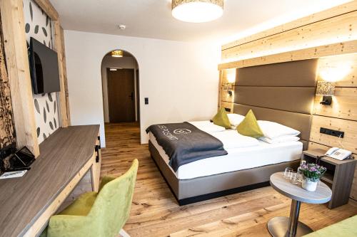 a hotel room with a bed and a table at Der Postwirt in Söll