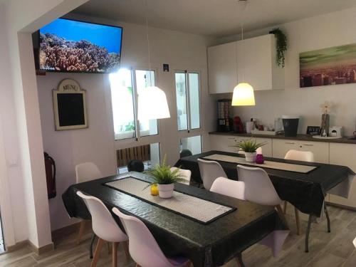 a dining room with tables and chairs and a kitchen at ViNALUX in Vinaròs