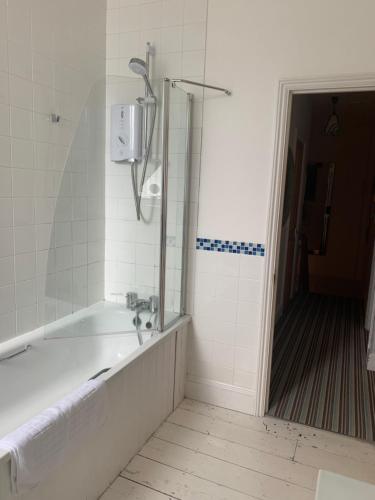 een badkamer met een bad en een douche bij Shoreline in St Ives