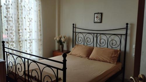 a bedroom with a black bed and a window at Anastasia's House near Kalamata in Dhesíllas