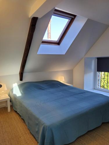 - une chambre mansardée avec un lit bleu dans l'établissement Ò FaYa Cottage votre Gîte calme et verdoyant en Bretagne, à Saint-Mayeux