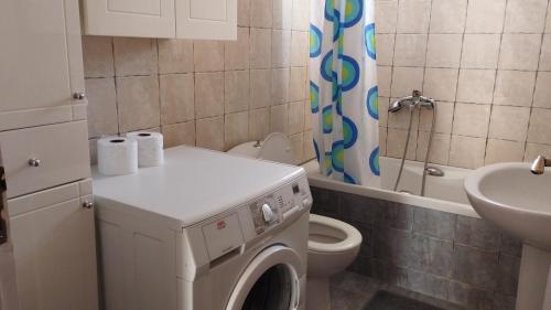 een badkamer met een wasmachine en een wastafel bij Anastasia's House near Kalamata in Dhesíllas