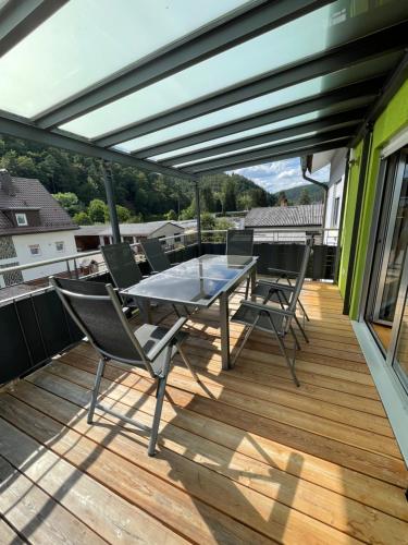 un patio con mesa y sillas en una terraza en Ferienwohnung Erika, en Dahn