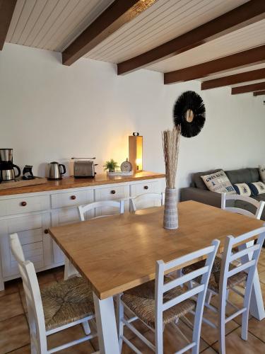 une cuisine et une salle à manger avec une table et des chaises en bois dans l'établissement Ò FaYa Cottage votre Gîte calme et verdoyant en Bretagne, à Saint-Mayeux