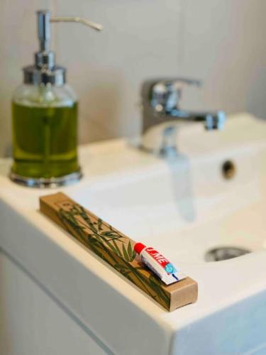 - une brosse à dents sur un comptoir de salle de bains à côté d'un lavabo dans l'établissement Enghien T2 Coeur de ville 12 mn de Paris, à Enghien-les-Bains