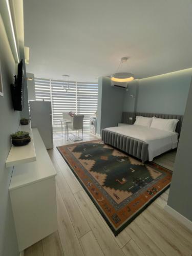 een slaapkamer met een bed en een woonkamer bij Comfort Apartment In City Center in Tirana