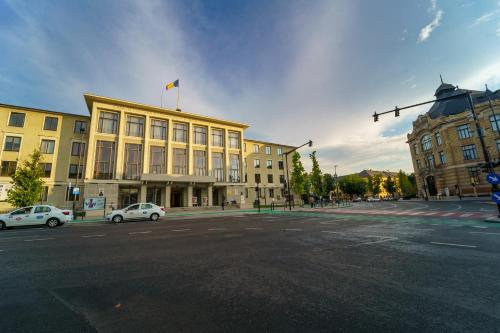 a large yellow building with a flag on top of it at Main square 5 star luxury apartment with view in Cluj-Napoca