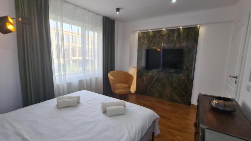a bedroom with a white bed and a television at Main square 5 star luxury apartment with view in Cluj-Napoca