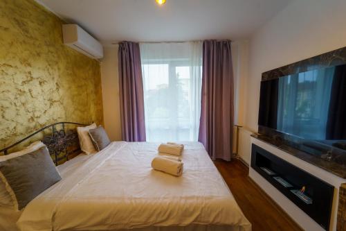 a bedroom with a bed with a flat screen tv at Main square 5 star luxury apartment with view in Cluj-Napoca