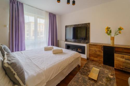 a bedroom with a bed with a fireplace and a tv at Main square 5 star luxury apartment with view in Cluj-Napoca