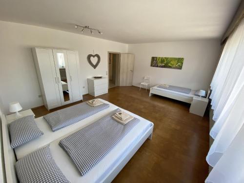 a white room with two beds and a living room at Ferienhaus Heimberg - Fischach in Fischach