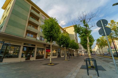 an empty street with trees in front of a building at Main square 5 star luxury apartment with view in Cluj-Napoca