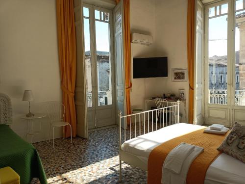 a hotel room with a bed and a balcony at B&B Perla in Catania