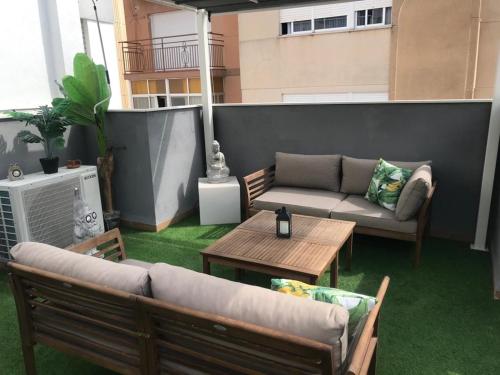a patio with two couches and a table on a balcony at ViNALUX in Vinaròs