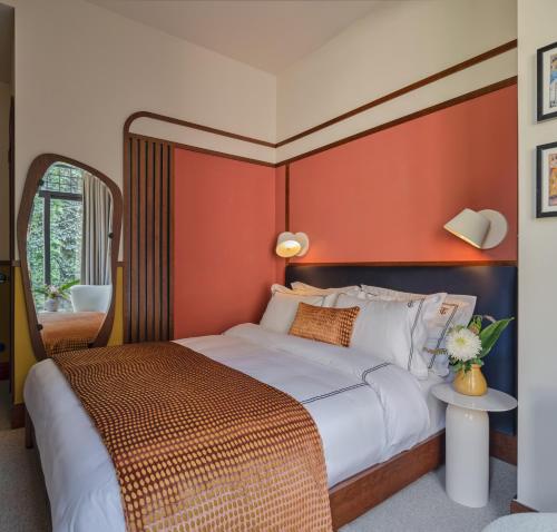 ein Schlafzimmer mit einem großen Bett und einer orangefarbenen Wand in der Unterkunft GentleTom in Istanbul