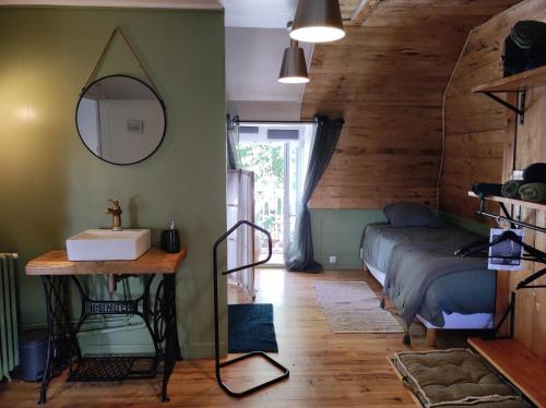 une chambre avec un lit et un miroir au mur dans l'établissement La Demeure de Cyr, à Saint-Chamant