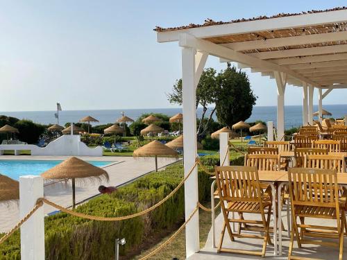 a group of chairs and tables next to a pool at Vivenda Jardim Mar Algarve Porches in Porches