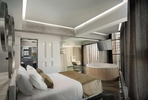 1 dormitorio con 1 cama grande y baño en Nautilux Rethymno by Mage Hotels, en Rethymno