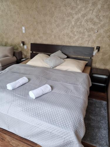 Una cama con dos almohadas enrolladas. en Študio PARADISE, en Santovka