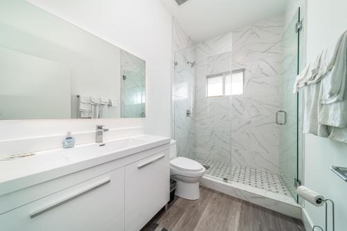 Un baño blanco con ducha y WC. en Pool Boutique Villa by the Beach 1, en Hallandale Beach