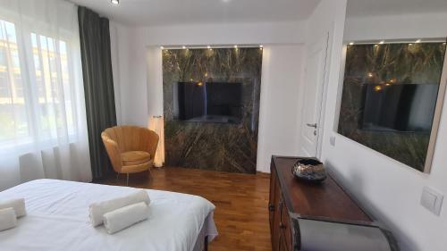a white bedroom with a bed and a television at Main square 5 star luxury apartment with view in Cluj-Napoca