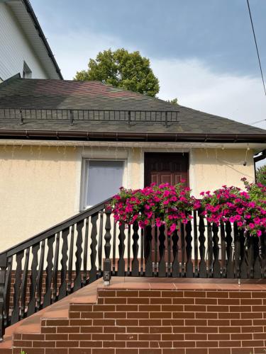 una casa con flores rosas en el balcón en MK Hornik Apartament en Kowary