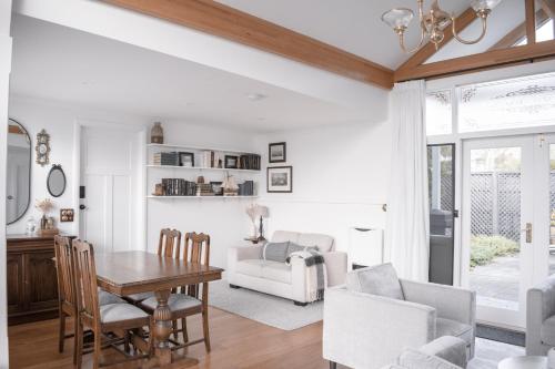 a living room with a table and chairs and a couch at Walton House in Huonville