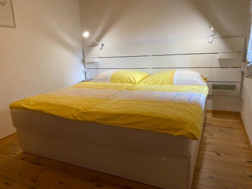 łóżko z żółtą pościelą i poduszkami w pokoju w obiekcie Haus Ebenberghof w mieście Zell am See