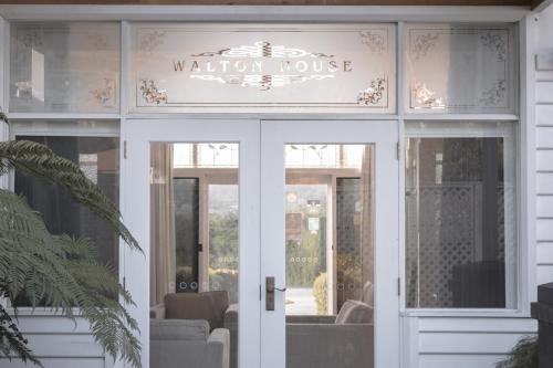 a door to a vacation house with a sign above it at Walton House in Huonville