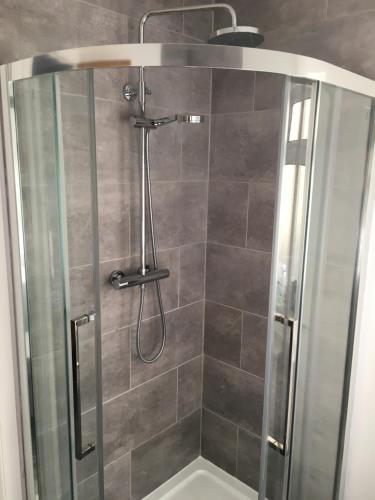 a shower stall with a glass door and a shower at Brecbennoch in Oban